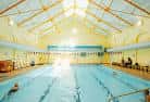 Vista interior de la piscina del Zest Centre con líneas de natación y estructura de techo