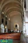 Interior de la iglesia con bóvedas y bancos de madera