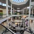 Interior del centro comercial con atrio central, escaleras y múltiples niveles