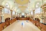 Interior del salón principal con techos altos, columnas y suelo de madera pulida