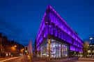Fachada iluminada en morado del edificio durante la noche