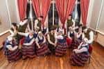 Grupo de bailarines folclóricos en el salón principal durante una actuación cultural