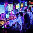 Clientes jugando en máquinas arcade dentro del local