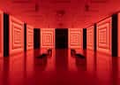 Interior del espacio expositivo con iluminación roja y paredes decoradas