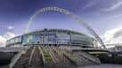 Vista frontal del Wembley Stadium con su icónico arco bajo un cielo azul