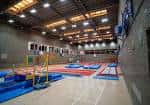Zona de actividades deportivas con colchonetas azules y rojas en el interior del centro