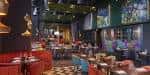 Interior del bar y grill con mesas y decoración colorida