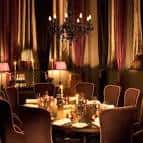 Sala de comedor elegante con mesa redonda y velas