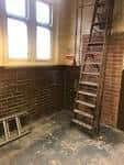 Espacio industrial con escalera metálica y pared de ladrillo