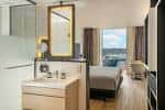 Interior de una habitación moderna con baño integrado y vista a la ciudad