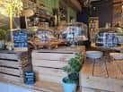 Interior del local mostrando mostrador de madera con productos y decoración vegetal