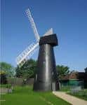 Molino de viento de Brixton en un día soleado con cielo azul y césped verde