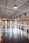 Vista panorámica del interior industrial con suelo de concreto pulido y vigas metálicas