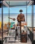 Exposición interior con maniquí militar y artefactos históricos en vitrina