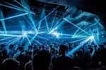Interior del club con sistema de luces láser azules y multitud bailando