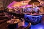 Área de bar en el interior del club Sway con luces cálidas