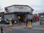 Entrada principal de la estación de metro Clapham North durante el día con peatones y bicicletas