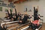 Clase grupal en el estudio Sano Studio con participantes usando equipos de Pilates