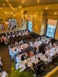 Salón decorado para una cena de evento con mesas y luces cálidas