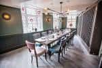 Sala de eventos privada con mesa larga y sillas modernas