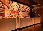 Recepción del hotel con arte mural colorido en la pared