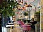 Interior elegante del hotel con mobiliario rosa y decoración clásica
