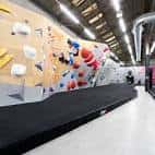 Interior del The Climbing Hangar con paredes de escalada y colchonetas