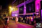 Fachada iluminada del Mansion Club Liverpool por la noche con luces de neón