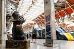 Interior de la estación con el famoso oso Paddington y trenes en los andenes