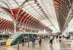 Plataforma con tren moderno y arquitectura distintiva de arcos rojos