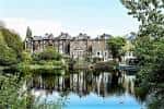 Edificio histórico junto a un lago rodeado de árboles en Hampstead Heath