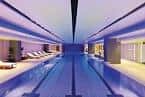 Piscina interior del hotel con iluminación azul y tumbonas
