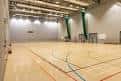 Vista interior de la pista deportiva principal con líneas marcadas y techo alto