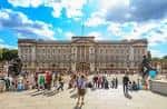 Fachada principal del Palacio de Buckingham con turistas en la plaza
