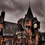 Fachada histórica del Tolbooth Tavern con torre y reloj bajo cielo nublado