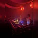 Escenario de DJ en el Gaffe London durante un evento nocturno con luces rojas