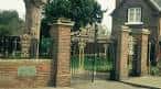 Entrada principal de Bridgford Park con portones de hierro y muros de ladrillo