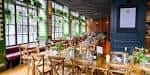 Interior del Singer Tavern con mesas dispuestas para eventos y decoración de plantas