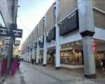 Vista exterior del centro comercial Lion Yard con fachada moderna y tiendas en planta baja