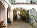 Pasillo cubierto con arcos y mobiliario al aire libre