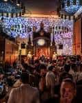 Interior del local con decoración de luces y público asistiendo a un evento