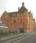 Vista exterior del Courtyard Theatre en Londres, edificio de ladrillo rojo con arquitectura clásica
