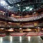 Interior del auditorio del Courtyard Theatre con butacas rojas y escenario iluminado