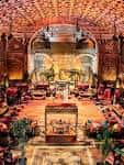 Interior del Gran Salón del Battersea Arts Centre decorado para una boda con iluminación cálida y mesas dispuestas