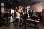 Interior del gimnasio Unite in Fitness con personas entrenando en zona de pesas