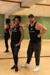 Dos instructores o miembros del equipo de Unite in Fitness posando en el interior del centro deportivo