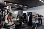 Zona de cardio del gimnasio Unite in Fitness con usuarios utilizando máquinas modernas