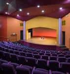 Interior del auditorio del Merlin Theatre con butacas y escenario
