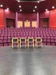 Vista del interior del teatro con sillas dispuestas en el escenario