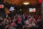 Público reunido en el pub viendo deportes en pantallas